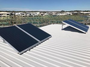 Solar hot water system panels mounted on a metal roof in North Lakes