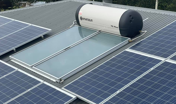 Solar hot water system installed on a metal roof alongside PV panels in North Lakes